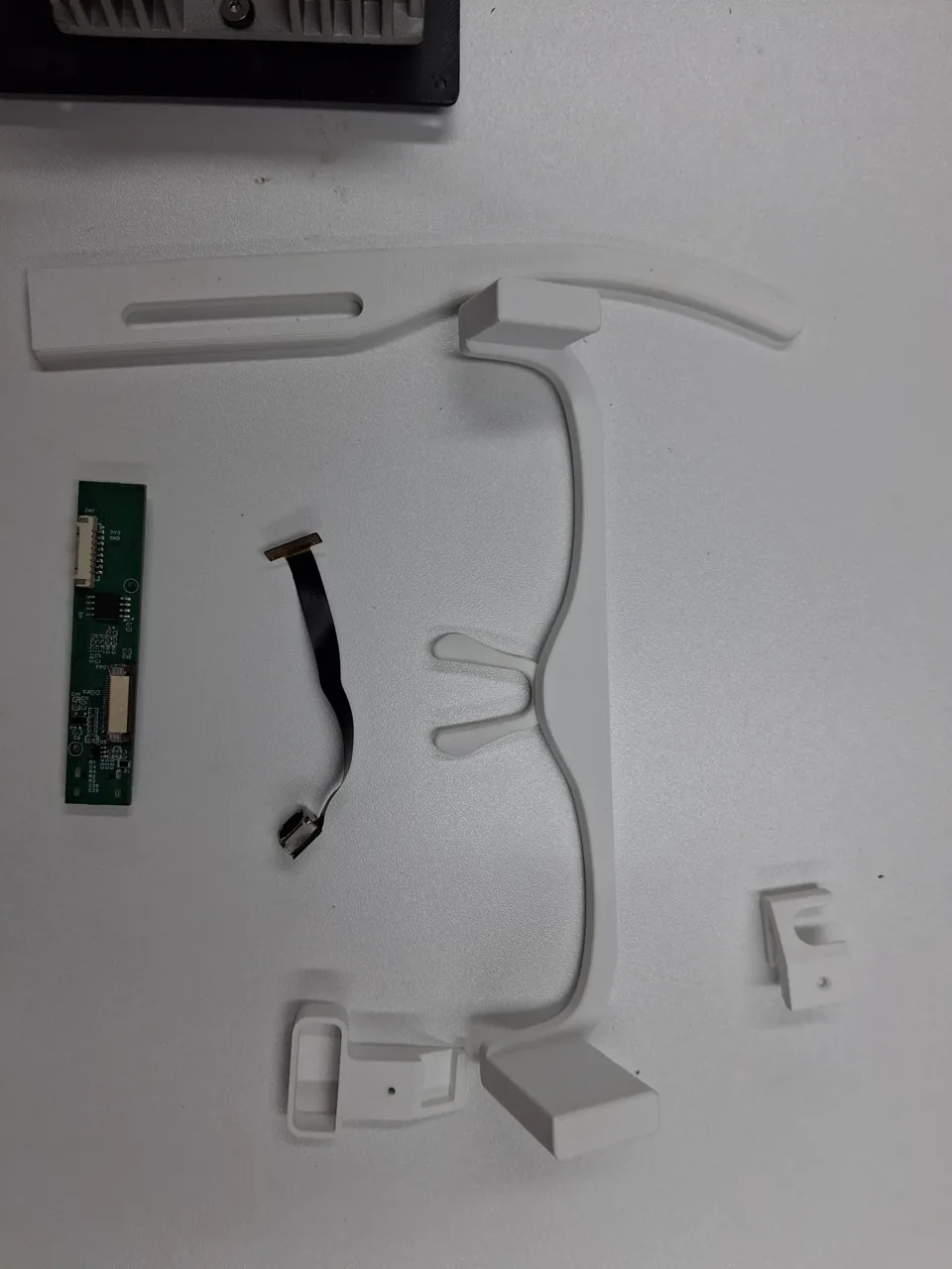 Glasses frame and electronic components laid out on a desk